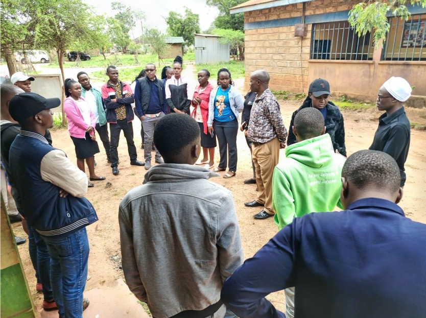 A group of people standing in a circle outdoors during field data collection