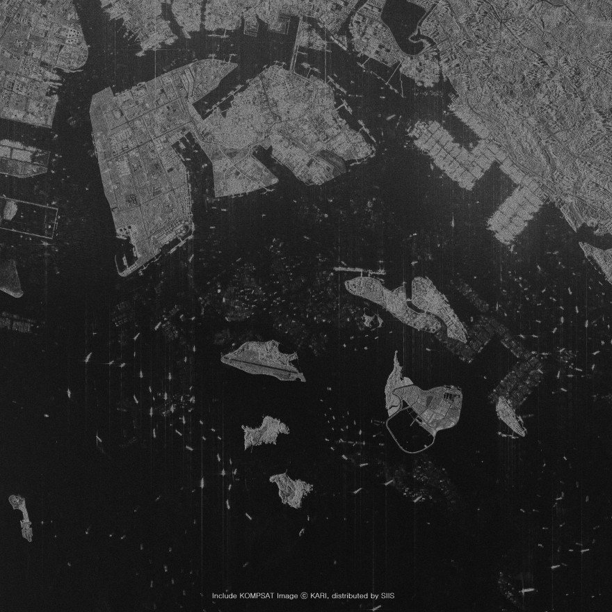 Radar satellite imagery in greys: a harbour city and islands, with ships at sea showing as scattered bright points on the dark water
