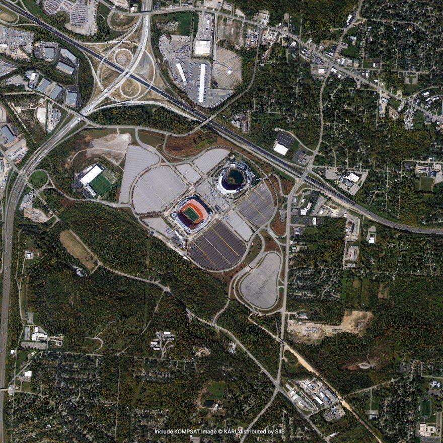 Satellite imagery of two stadiums in a sea of car parks, beside a motorway interchange and surrounded by woodland