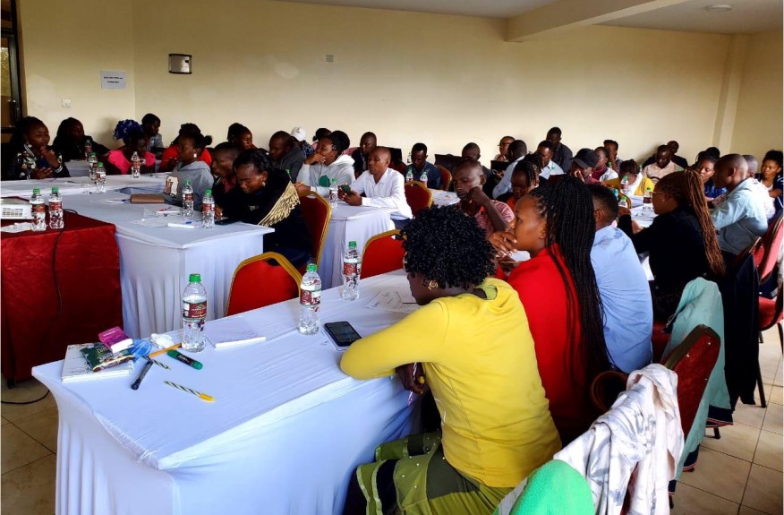 County data collectors seated at tables during a training session
