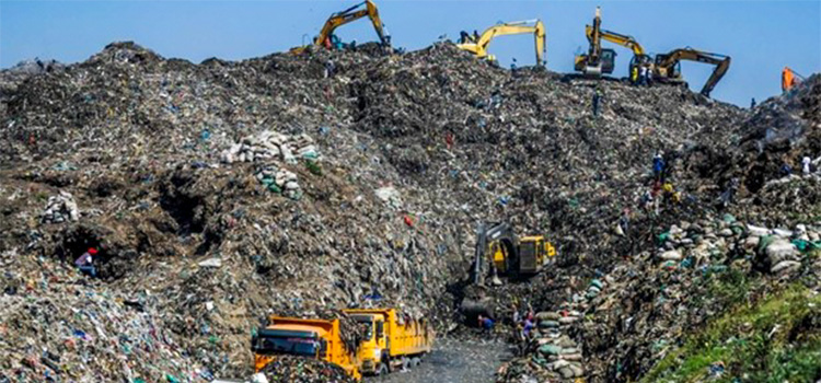 Excavators and tipper lorries working on a vast mound of mixed waste at a dumpsite, waste pickers on its slopes